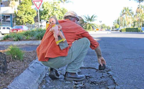 Lismore’s phantom pothole painter (and repairer) with his ‘baby on board’. Lismore’s phantom pothole painter (and repairer) with his ‘baby on board’.